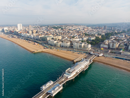 Aerial photo of the famous Brighton Pier and ocean located in the south coast of England UK that is part of the City of Brighton and Hove, taken on a bright sunny day showing the fairground rides. © Duncan