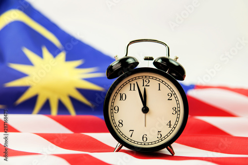 alarm clock and Malaysia flag on white background photo