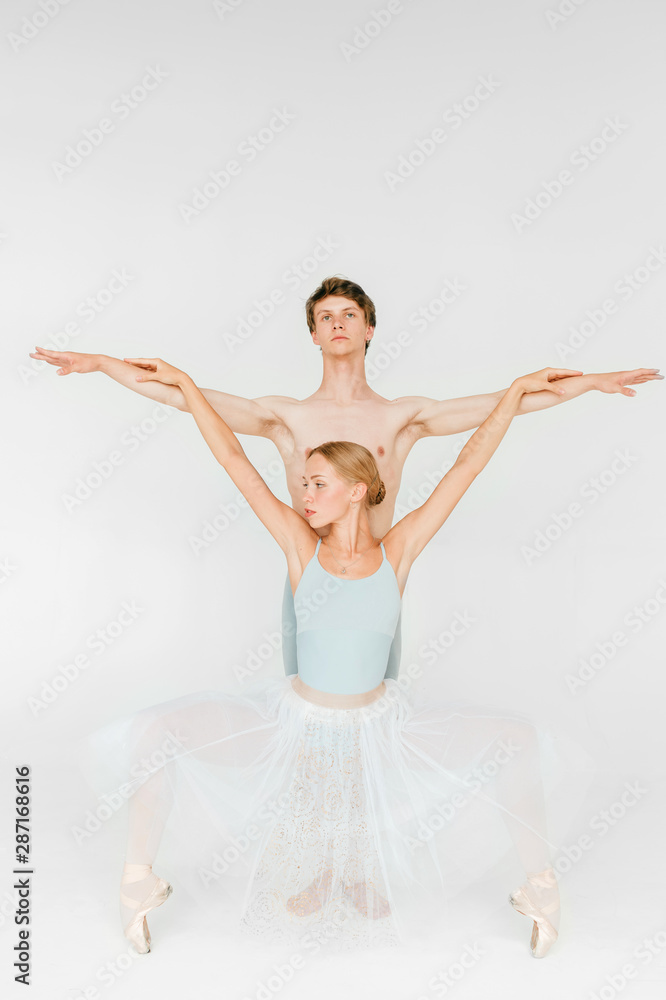Naklejka premium Two athletic modern ballet dancers are posing against white studio background
