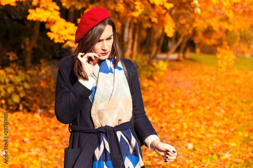 Woman talking by cellphone in the autumn park photo