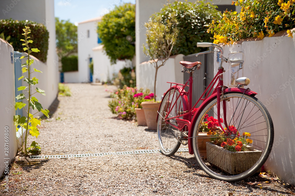 Fototapeta premium Vieux vélo rouge dans les rues d'un village Vendéen