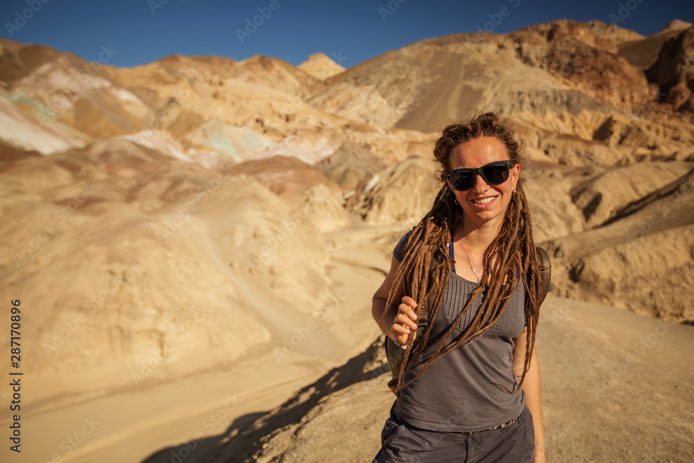 Naklejka premium A hiker in the Artist`s Palette landmark place in Death Valley National Park, Geology, sand.