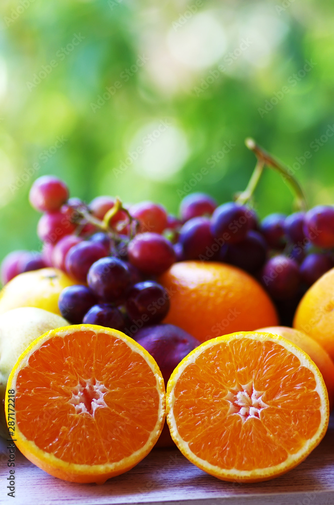 sliced oranges and grapes, green background sliced oranges and grapes, green background