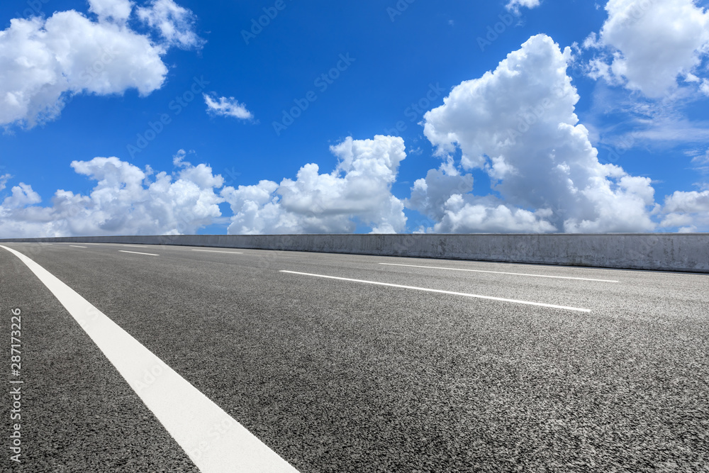 Fototapeta premium Asphalt highway road and blue sky with white clouds