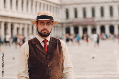 Young man in vintage suit stand on Piazza San Marco Square in Venice, Italy