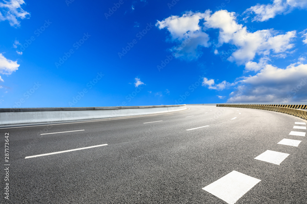 Fototapeta premium Asphalt highway road and blue sky with white clouds