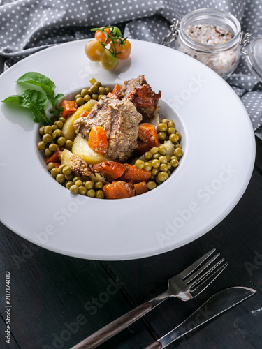 Closeup: Potatoes, carrots, green peas and turkey meat on a white plate. Baked meat with vegetables