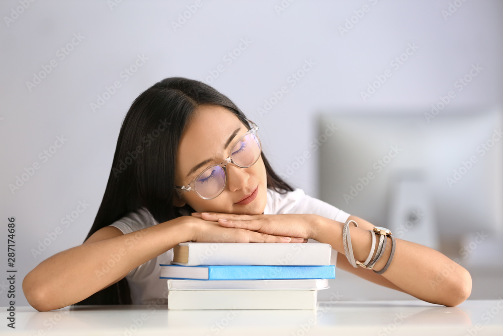 Sleeping young Asian student with books at table Sleeping young Asian student with books at table