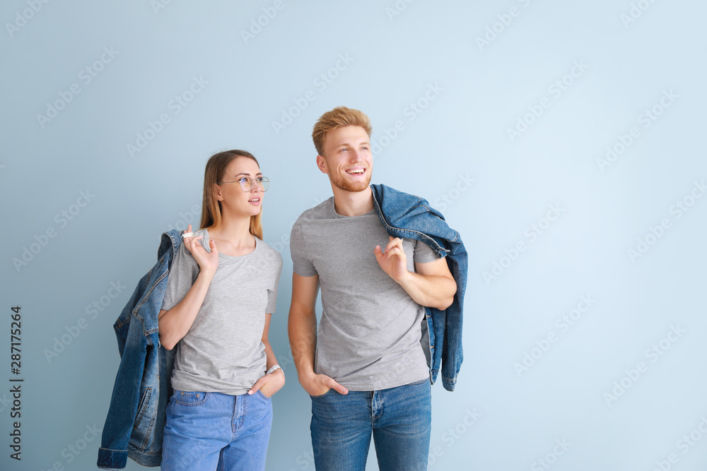 Couple in stylish t-shirts on color background Couple in stylish t-shirts on color background