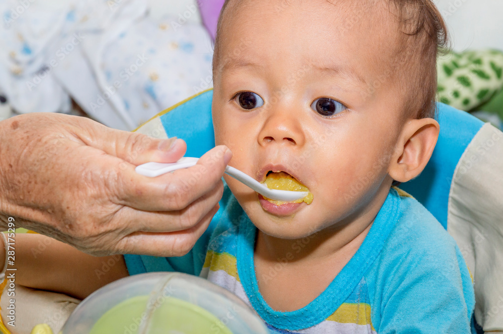 Grandma is feeding soft food to grandchildren. Grandma is feeding soft food to grandchildren.