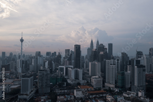 Aerial drone view of Kuala Lumpur city skyline during cloudy day