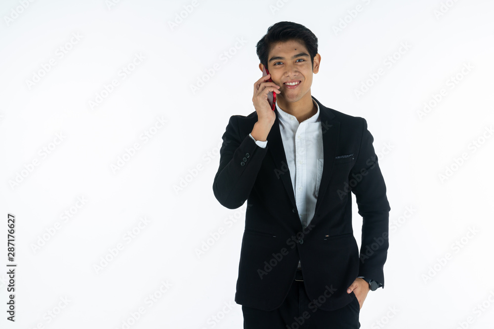 Handsome young businessman Asian caucasian wear a black suit with black hair, be a smile and standing smart poses. Hold and use a smartphone. On white background. Handsome young businessman Asian caucasian wear a black suit with black hair, be a smile and standing smart poses. Hold and use a smartphone. On white background.