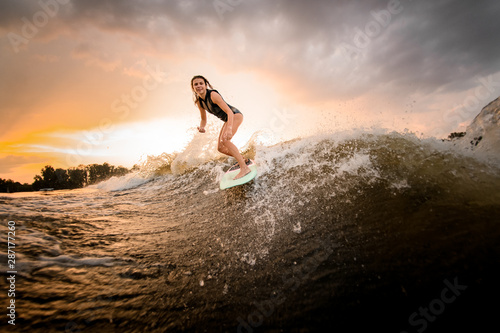 Girl riding on the wakeboard on the river on the wave