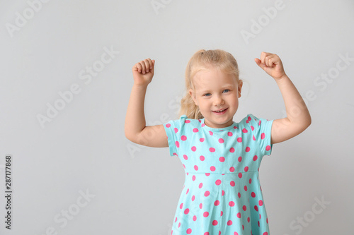 Happy little girl on light background