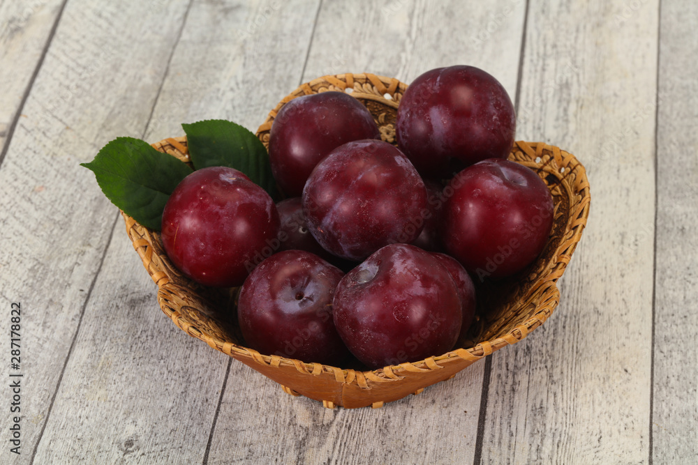 Plum heap in the wooden basket Plum heap in the wooden basket