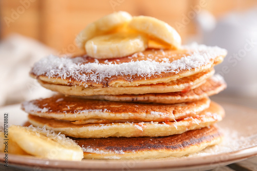 Tasty pancakes with banana on plate, closeup