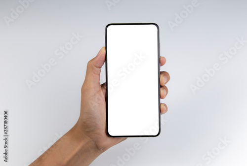 Hand holding the black smartphone with blank screen isolated on white background with clipping path.
