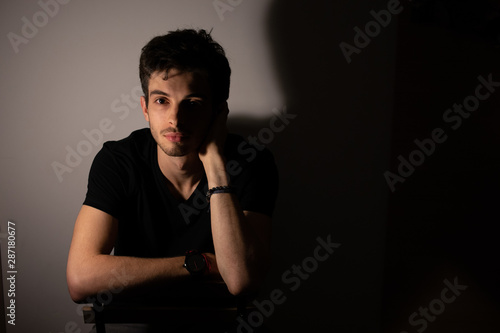 Young man teenager shadows light portrait looking forward © PetitNuage