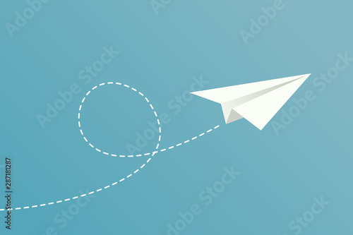 White paper plane flying on blue sky background photo