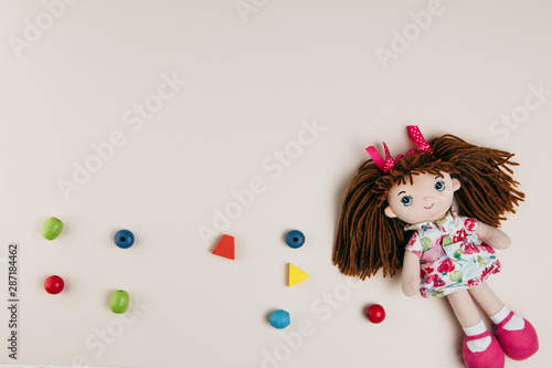 Canvas-taulu A doll and colourful objects on a white background