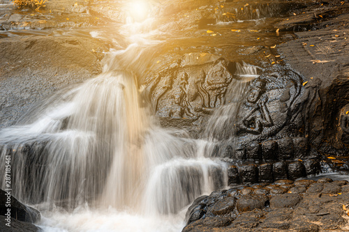 Waterfall flows through the carved statue photo