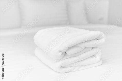 The white towels were neatly folded and placed on the white bed. Hotel services