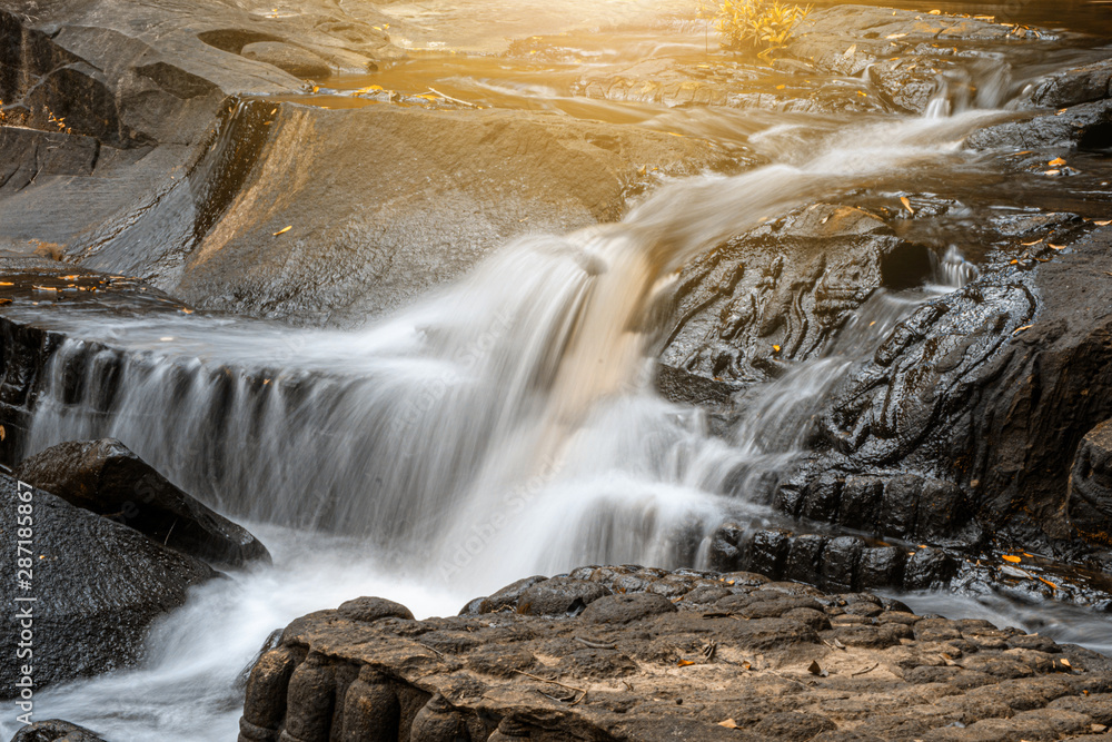 Obraz premium Waterfall flows through the carved statue