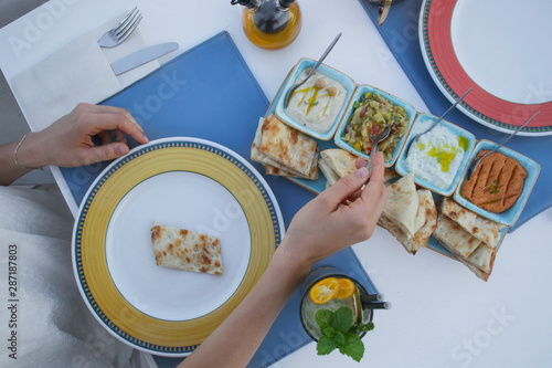 Woman having an appetizer before dinner. Mediterranean mezes served with freshly baked tandoori bread. photo