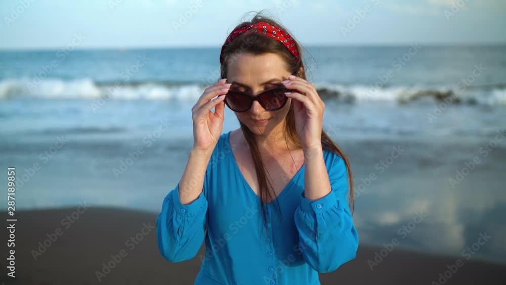 Portrait of a woman in a beautiful blue dress on a black volcanic beach. Slow motion Portrait of a woman in a beautiful blue dress on a black volcanic beach. Slow motion