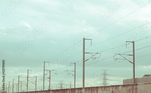 Street electricity poles aligned on the road with beautiful blue sky in background
