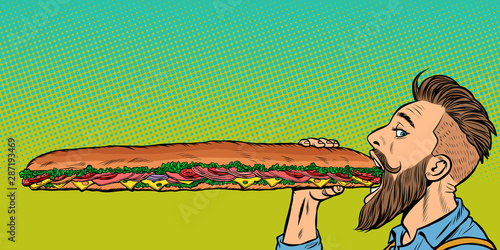 man eats a long sandwich