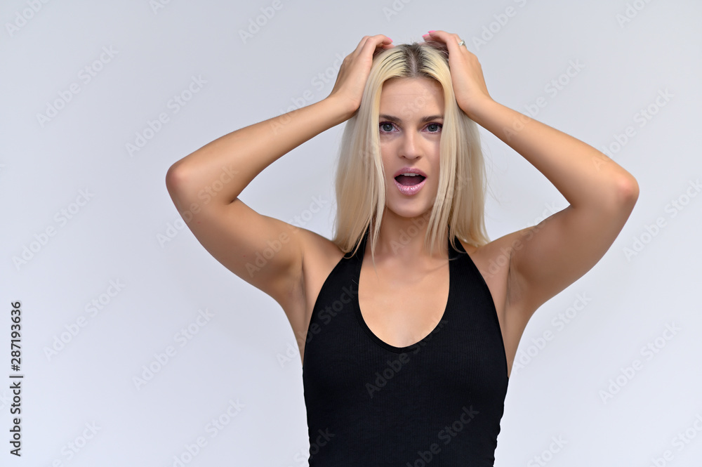 Fototapeta premium Portrait of a cute girl, a young blonde woman with beautiful curly hair in a black T-shirt on a white background. Beauty, brightness, smile, emotions.