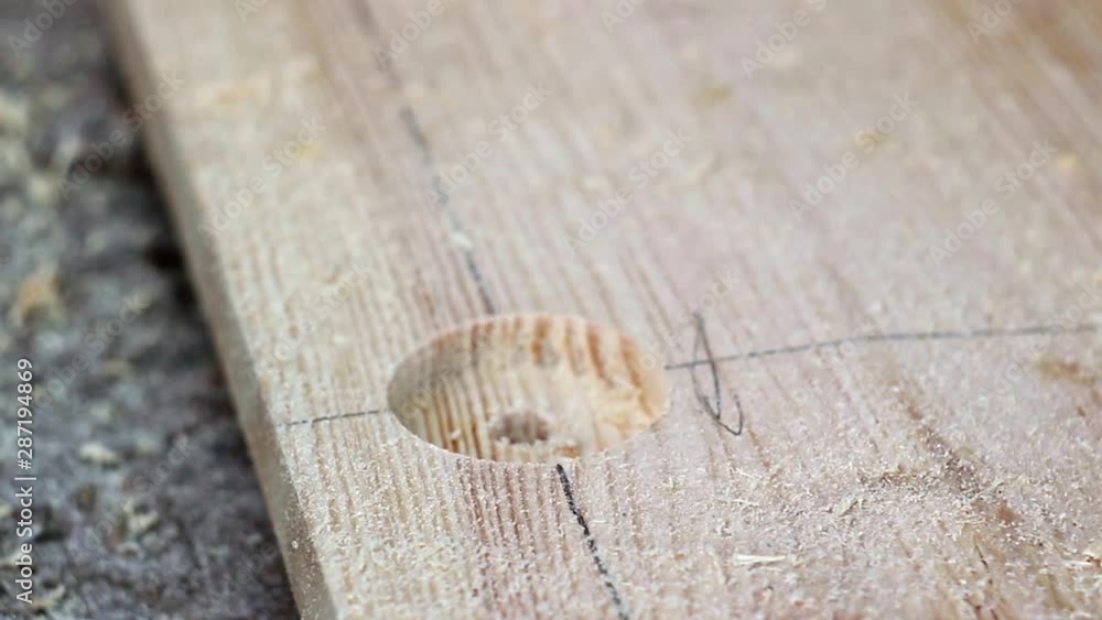 Drill round holes in a wooden board. Carpenter. Metal drill Drill round holes in a wooden board. Carpenter. Metal drill