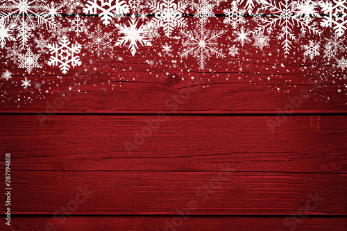 Red Christmas winter background with snowflakes on wood