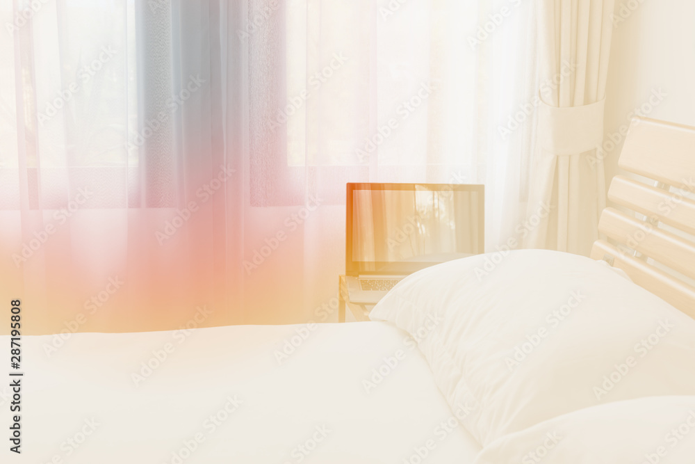 Computer notebook in modern white bedroom interior in morning light Computer notebook in modern white bedroom interior in morning light