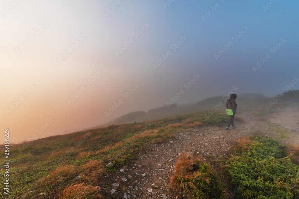 Evening on a mountain ridge with mystical fogs and scenery in the Ukrainian Carpathians.