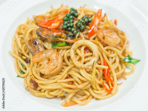 Spaghetti spicy with seafood on a white plate