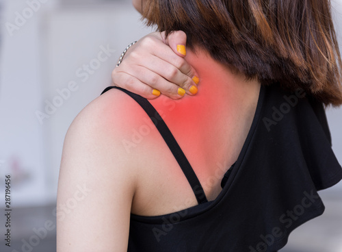 Asian woman having a neck pain, stiffness, injury on shoulder and neck,chronic pain