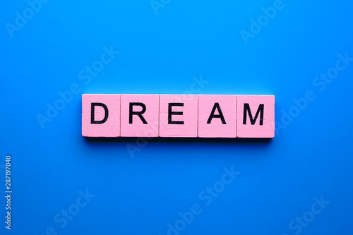 Dream word wooden cubes on a blue background