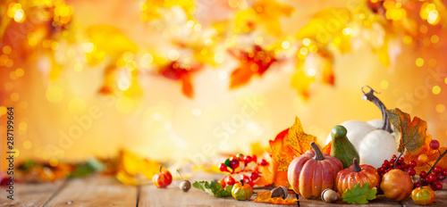 Autumn background from fallen leaves and pumpkins on wooden vintage table. Autumn concept with red-yellow leaves background. Thanksgiving pumpkins. photo