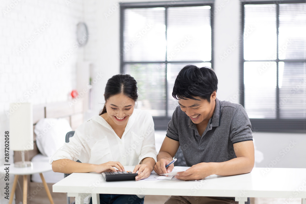 Couples are calculating expenses and bills.they are happy Couples are calculating expenses and bills.they are happy