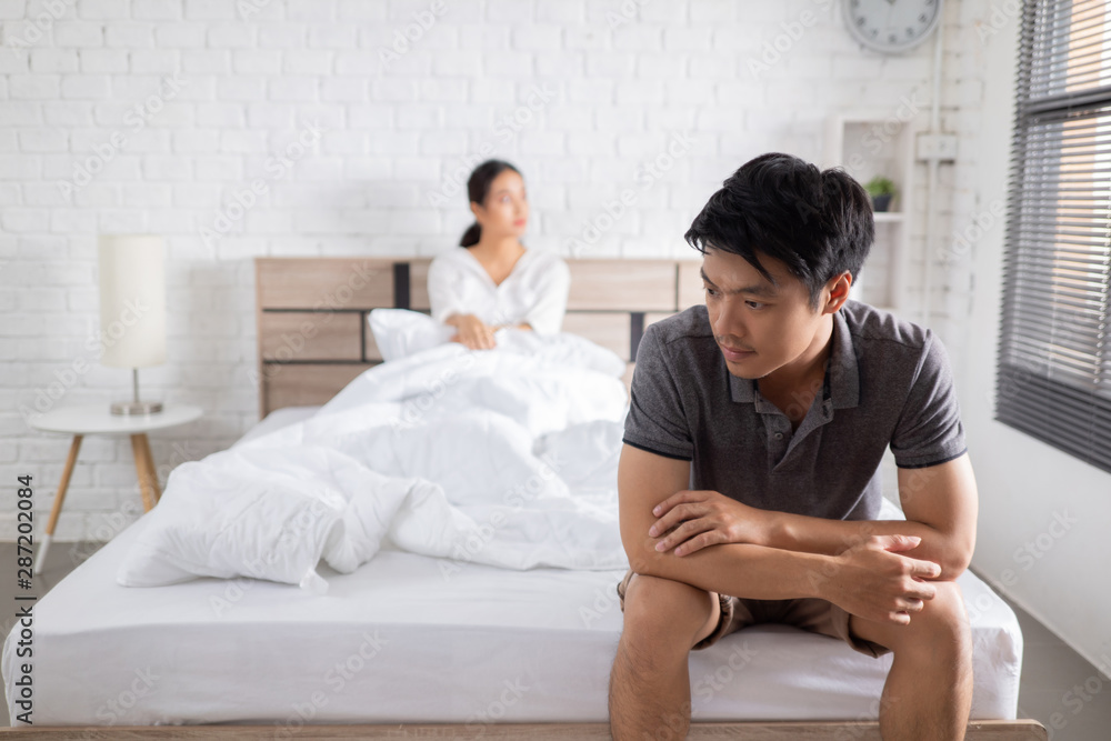 couple,they have problems with quarrel. man sitting in bed he is stressed couple,they have problems with quarrel. man sitting in bed he is stressed