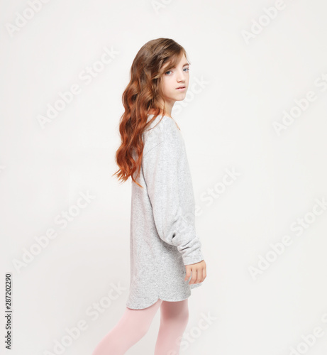 Beautiful little fashion model girl on white background. Portrait of cute smiling girl © Raisa Kanareva