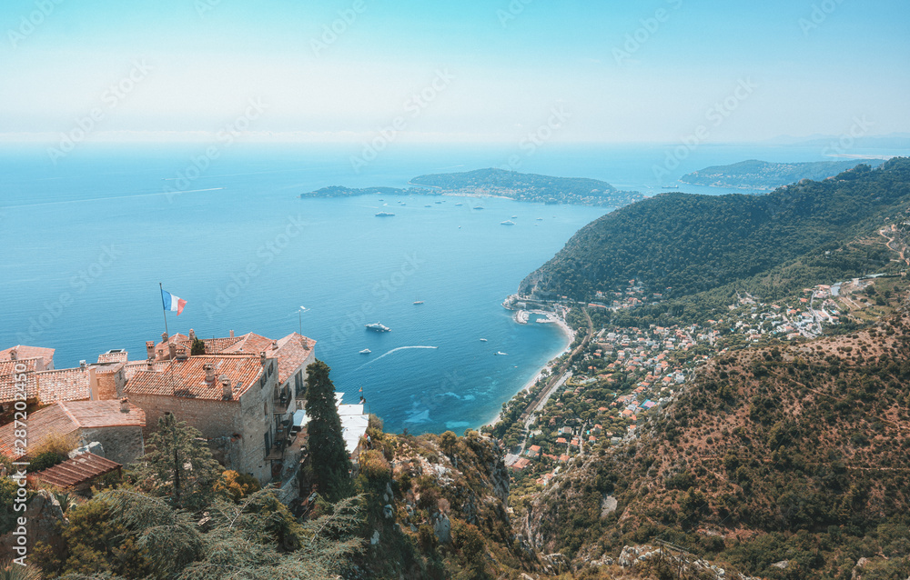 view on the Mediterranean Sea over the roofs of the picturesque medieval village of Eze with the Saint-Jean-Cap-Ferrat peninsula on the horizon