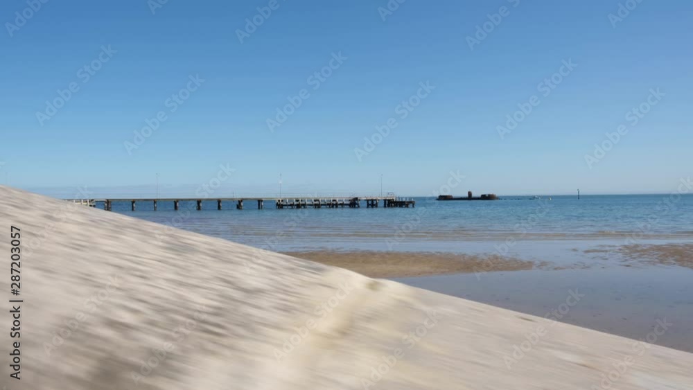 Upward movement along concrete slab against shallow ocean water on bright morning Upward movement along concrete slab against shallow ocean water on bright morning