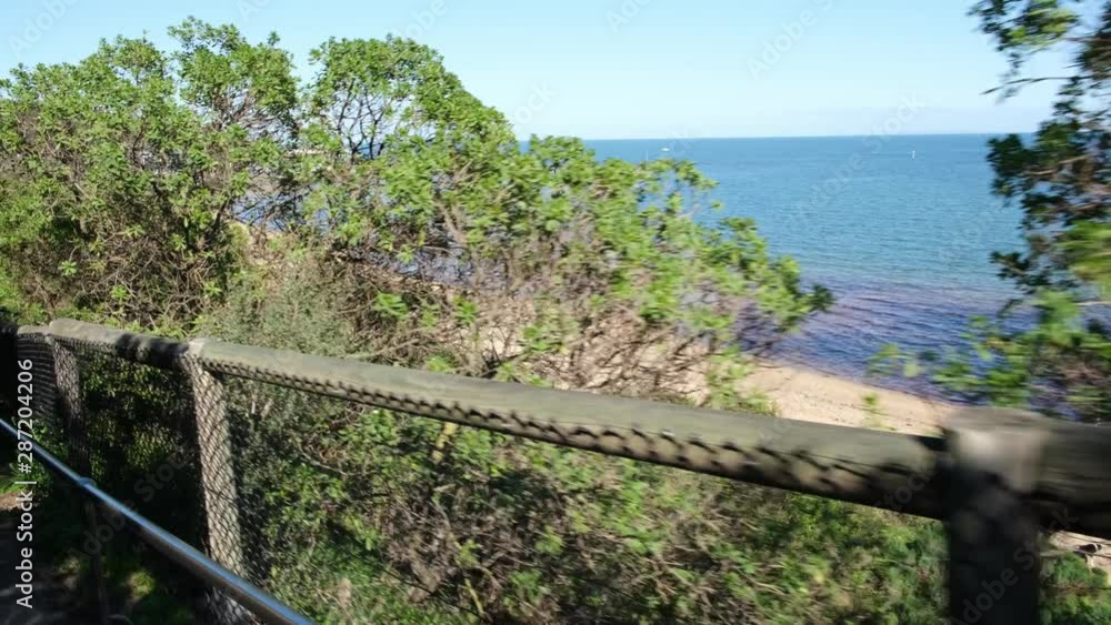 Forward cameara movement along wooden fence in coastal bush revealing the ocean bay in Australia Forward cameara movement along wooden fence in coastal bush revealing the ocean bay in Australia