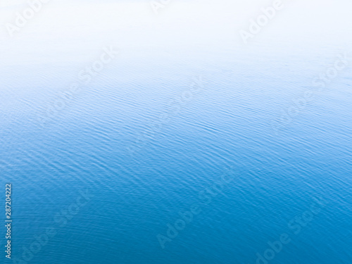 Unique blue background. Blue sea water surface texture background with white copy space on top.