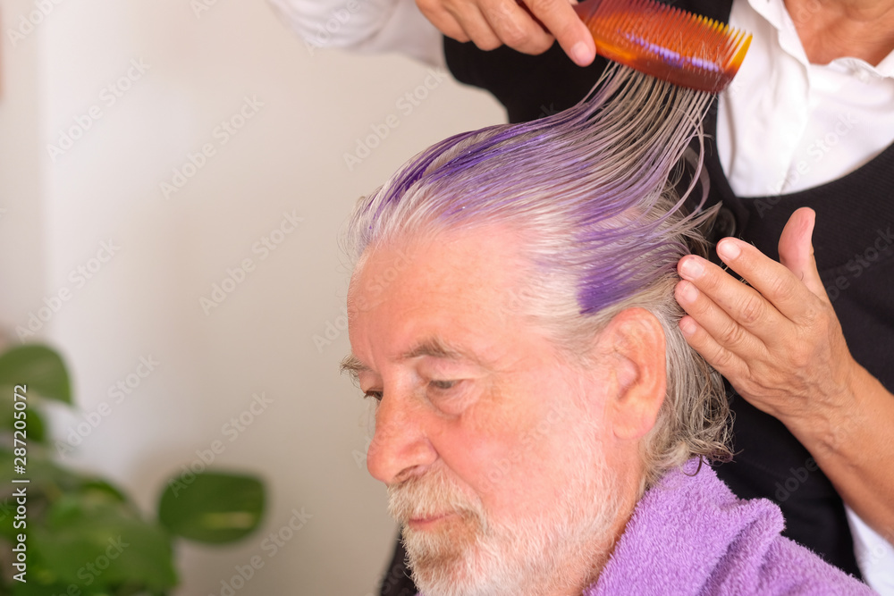 A handsome man with white and gray hair and beard relies on the confident  hands of