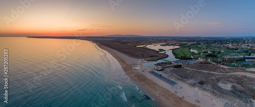 Aerial sunset seascape of Salgados beach in Albufeira, Algarve tourism destination region, Portugal.