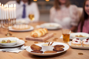 Hanukkah dinner. Family gathered around the table with traditional dishes